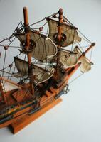 Haut vue de une miniature voile navire fabriqué de bois sur une souvenir supporter isolé sur blanc photo