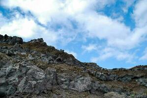 une rocheux Montagne avec une bleu ciel et des nuages photo