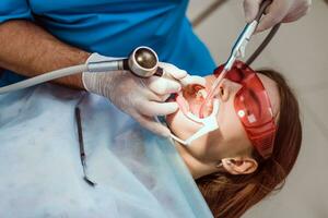 médecin orthodontiste effectue une procédure pour nettoyage les dents photo