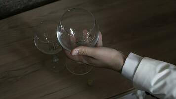 Masculin main en portant une verre de vin sur une en bois table dans une restaurant photo