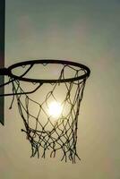 une basketball cerceau avec le Soleil brillant par il photo