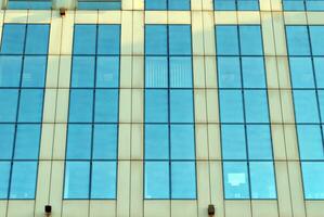 de construction verre mur reflétant bleu ciel. abstrait moderne architecture fragment. photo