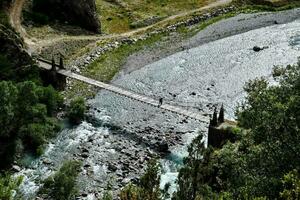 une suspension pont plus de une rivière dans le montagnes photo