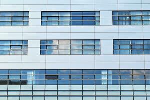 moderne Bureau bâtiment dans le ville avec les fenêtres et acier et aluminium panneaux mur. photo