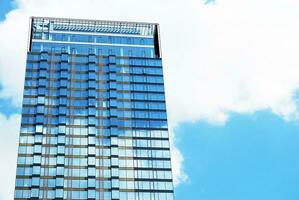 de construction verre mur reflétant bleu ciel. abstrait moderne architecture fragment. photo