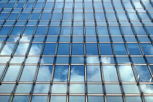 de construction verre mur reflétant bleu ciel. abstrait moderne architecture fragment. photo