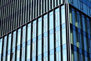 de construction verre mur reflétant bleu ciel. abstrait moderne architecture fragment. photo