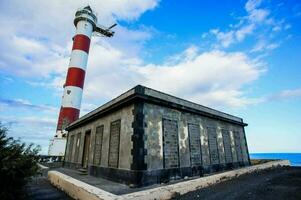 une phare sur le côte avec une bâtiment suivant à il photo