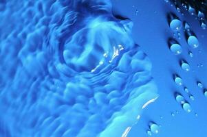 l'eau gouttelettes sur une bleu surface photo