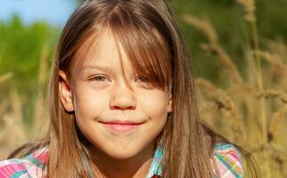 portrait de caucasien peu fille de 6 sept ans souriant et à la recherche à caméra à l'extérieur dans l'automne champ photo