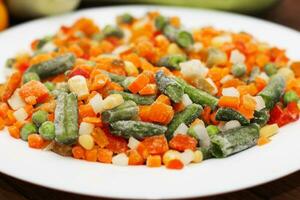 congelé des légumes carottes, petits pois, des haricots dans une plaque. photo