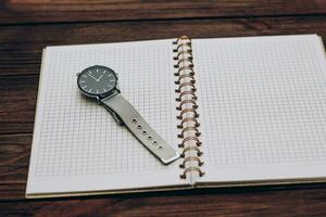 ouvert carnet journal intime avec l'horloge avec noir cadran, temps la gestion concept. photo