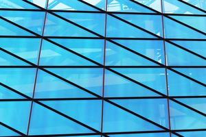 mur de fenêtre en verre d'un immeuble moderne avec reflet du ciel bleu photo