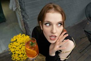 portrait de une magnifique amusement Jeune femme avec une verre de cocktail photo