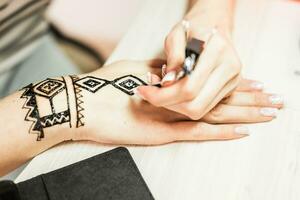 Jeune femme mehendi artiste La peinture henné sur le main photo