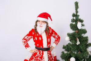 marrant fille dans portant Noël Père Noël costume plus de Noël arbre Contexte. vacances, blague et gens concept photo