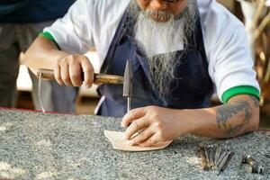 fermer et surgir cuir artisan est soigneusement à faire une cuir produit pour une client., cuir artisan concept. photo