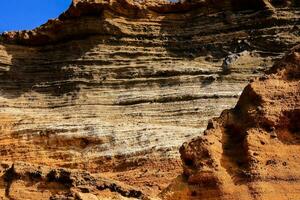 une grand Roche formation dans le désert avec une bleu ciel photo
