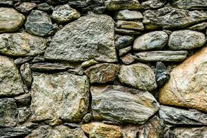 une pierre mur avec beaucoup différent les types de rochers photo