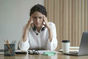 stressé femelle professionnel avec mal de crâne à travail, sentiment épuisé photo