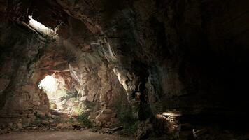 une mystérieux la grotte illuminé par une faisceau de lumière photo