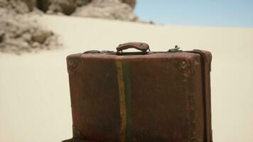 une pièce de bagage séance sur Haut de une sablonneux plage photo