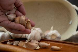 Masculin mains placement Ail sur une en bois assiette photo