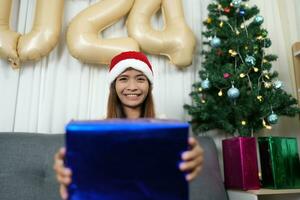 joyeux Noël 2024 concept asiatique femmes sont content à recevoir cadeaux sur Noël journée. photo