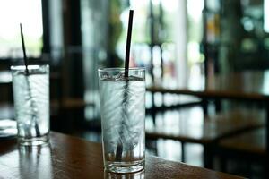 l'eau verre avec la glace dans le verre sur le à manger table photo