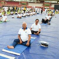 Nouveau Delhi, Inde, juin 21, 2023 - groupe yoga exercice session pour gens à yamuna des sports complexe dans delhi sur international yoga jour, gros groupe de adultes assister yoga classe dans criquet stade photo