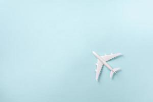 avion blanc, avion sur fond de couleur pastel bleu avec espace de copie. vue de dessus, mise à plat. conception de style minimal. voyage, concept de vacances photo