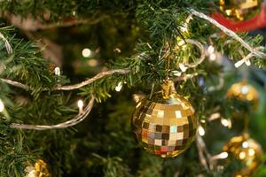 proche en haut de le briller des balles décoration sur le Noël arbre avec LED lumières. photo