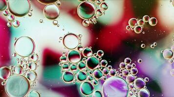 huile alimentaire colorée abstraite laisse tomber des bulles et des sphères qui coule sur la surface de l'eau photo