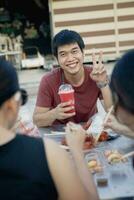 asiatique homme souriant avec bonheur souhait cool boisson bouteille dans main photo