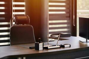 lieu de travail de bureau d'affaires. la lumière du soleil sur le lieu de travail pour le chef, le patron ou d'autres employés. table et chaise confortable. lumière à travers les stores à demi ouverts photo