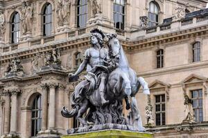 une statue de une homme sur une cheval dans de face de une bâtiment photo