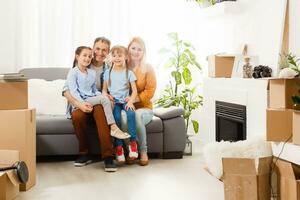 content famille avec papier carton des boites dans Nouveau maison à en mouvement journée. photo