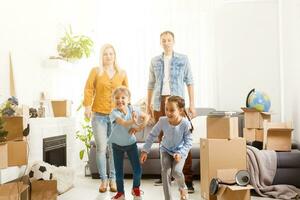 content famille avec papier carton des boites dans Nouveau maison à en mouvement journée. photo