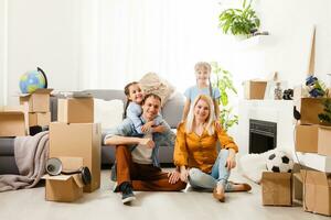 content famille avec papier carton des boites dans Nouveau maison à en mouvement journée. photo