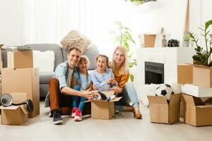 content famille avec papier carton des boites dans Nouveau maison à en mouvement journée. photo