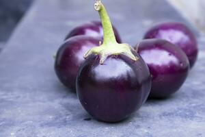 Frais aubergine sur une noir béton sol. sélectif se concentrer, agricole concept, cultivé des légumes photo