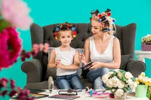 portrait de mignonne peu fille et sa maman Faire chaque autre maquillage photo