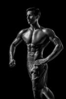 musclé et en forme Jeune bodybuilder aptitude Masculin modèle posant ove photo