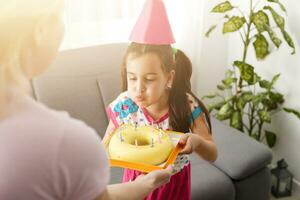 content fille enfant de mêmes parents célébrer anniversaire via l'Internet dans quarantaine temps, auto-isolement et famille valeurs, en ligne anniversaire faire la fête. toutes nos félicitations animateur via ordinateur portable, en ligne. rester à Accueil photo