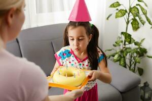 content fille enfant de mêmes parents célébrer anniversaire via l'Internet dans quarantaine temps, auto-isolement et famille valeurs, en ligne anniversaire faire la fête. toutes nos félicitations animateur via ordinateur portable, en ligne. rester à Accueil photo