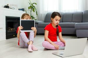 peu les filles en jouant sur une tablette l'informatique dispositif séance sur le sol photo