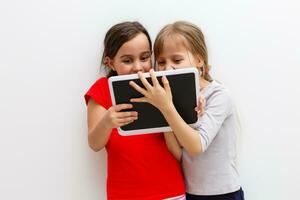 image de deux magnifique les filles avec tablette PC sur blanc Contexte photo