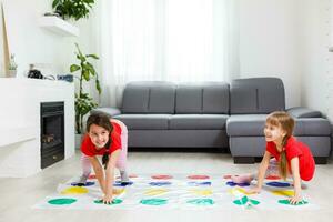 deux peu les filles ayant amusement en jouant Jeu sur sol à maison. Fratrie relation amicale photo