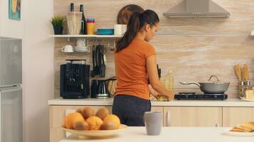 femme cueillette en haut des œufs de frigo à cuisinier petit déjeuner. . femme au foyer avoir impuissant des œufs et autre Ingrédients de réfrigérateur dans sa cuisine. photo