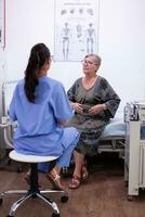 Sénior vieux femme parlant à Jeune femelle infirmière médecin Aidez-moi patient à vérification médical consultation à hôpital, personnes âgées grand-mère Ecoutez soignant donnant soutien, plus âgée gens soins de santé concept photo